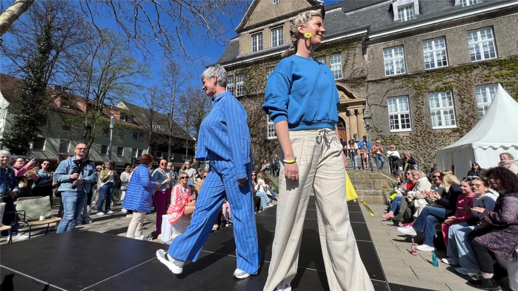 Zwei Frauen laufen auf der Modenschau auf dem Holzwickeder Marktplatz.