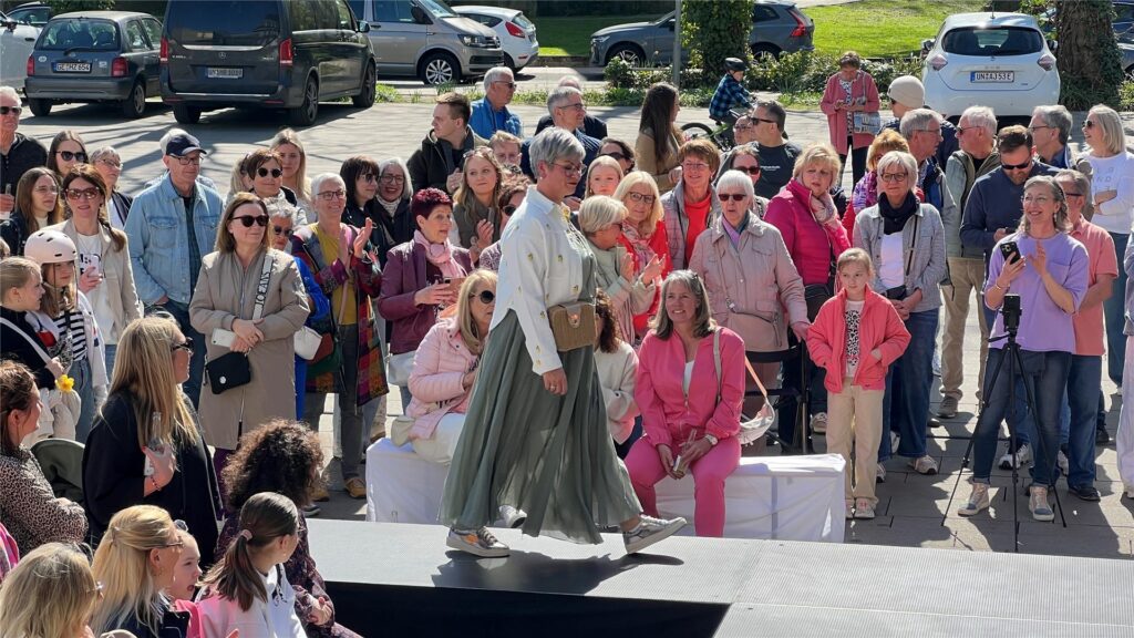 Zahlreiche Besucherinnen und Besucher genießen das sonnige Wetter bei der Modenschau von DekoRieger.