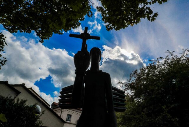 Ein Kreuz im Gegenlicht vor der St. Suitbertuskirche in der Dortmunder Innenstadt