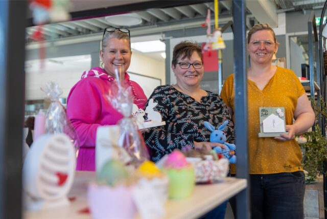 Farina Koch (v.l.), Manuela Dörr und  „Moni“ Terbrack stehen mit einigen ihrer Häkelfiguren im Caféplus in Vreden