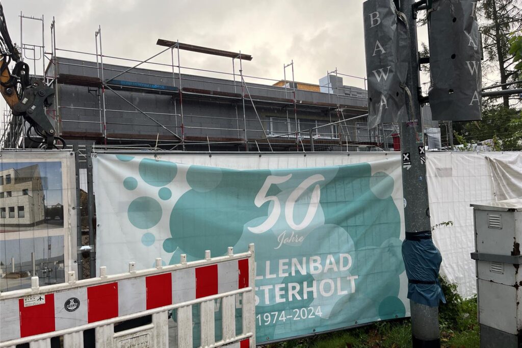 Ein Schild an einem Baustellenzaun weist auf das 50-jährige Jubiläum des Hallenbads Westerholt hin.
