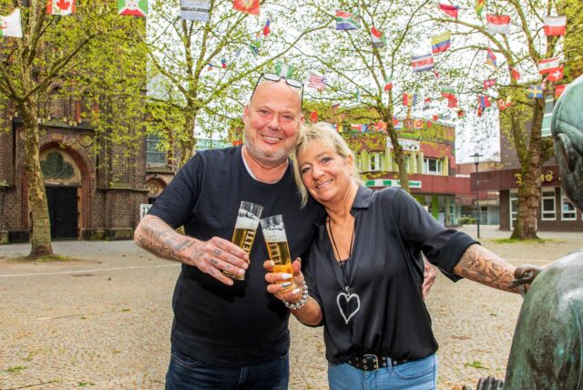 Sandra und Dirk Lasarz stehen auf dem Antoniusplatz in Herten-Mitte und stoßen mit einem Glas Bier an.