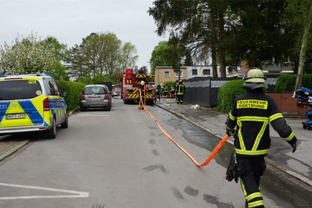 Feuerwehrmann und einsatzfahrzeuge im Schotteweg in Dortmund-Kirchlinde.