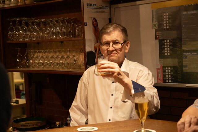 Wirt Michael Smajlovic hält am 27.9.2024 ein Bierglas in seiner Kneipe „Martener Hof“ fest. An diesem Freitagabend hat der Wirt zum letzten Mal seine Traditionskneipe geöffnet.