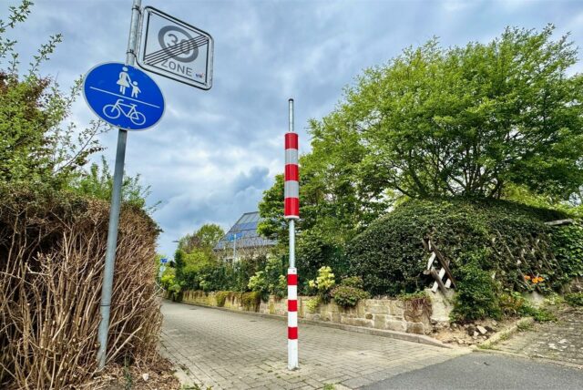 Drei Meter hoher Leitzylinder auf einem Fuß- und Radweg.