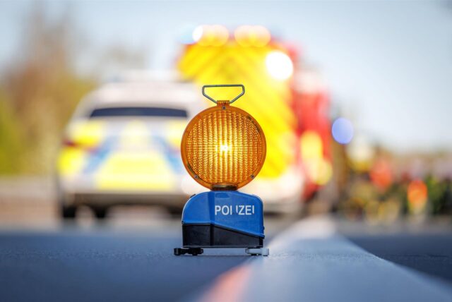 Auf einer Autobahn steht ein Warnblinklicht der Polizei