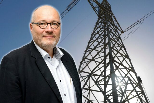 Christian Rehtanz, Professor an der TU Dortmund, ist neben einem Strommast zu sehen.