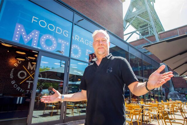 Mitbetreiber Carsten Kubacki steht mit ausgebreiteten Armen vor dem Restaurant Foodgarage Moto59 in Herten.