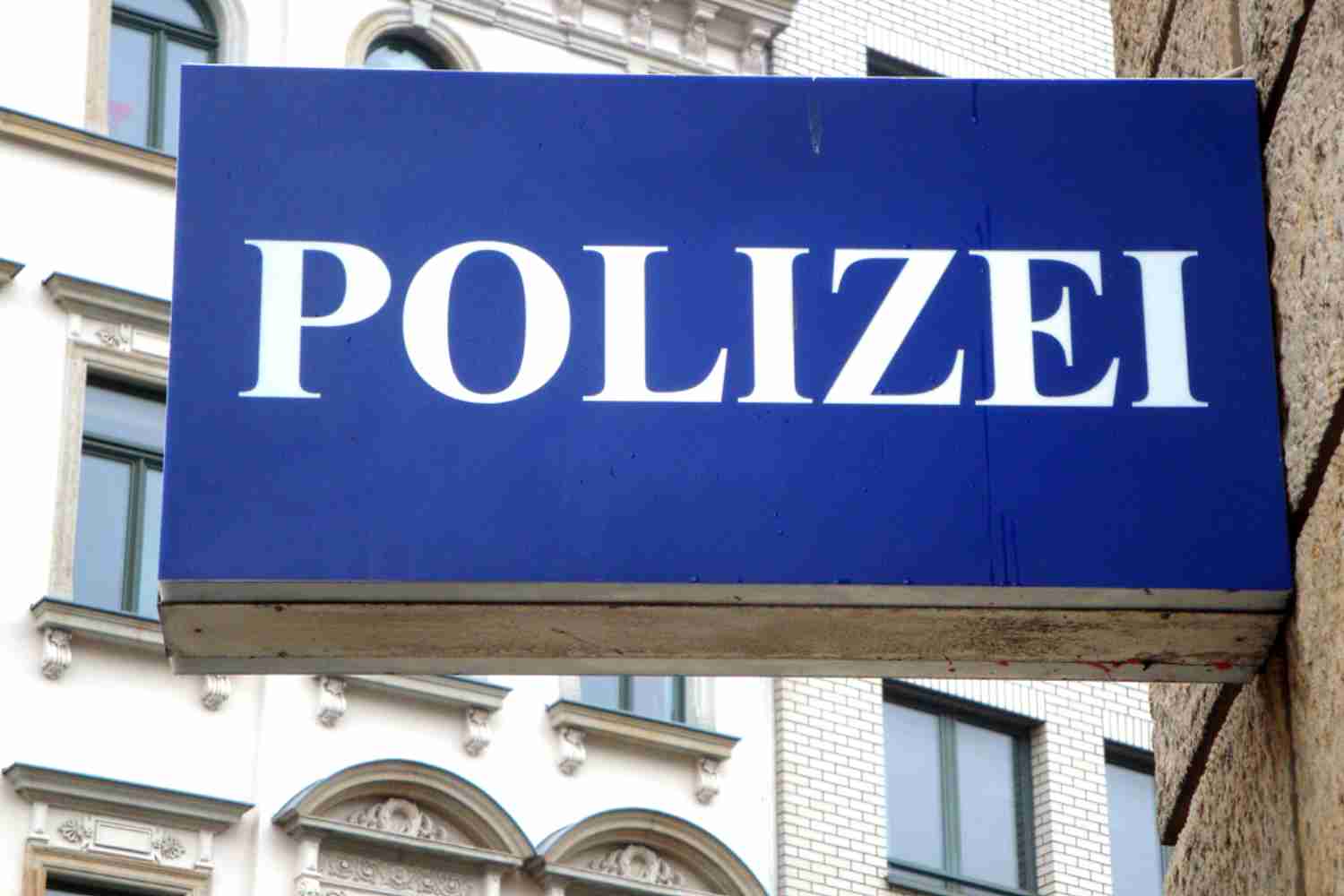 Schild an einer Hauswand mit der Aufschrift Polizei.