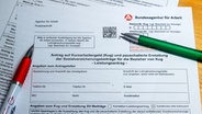 Zwei Kugelschreiber liegen auf einem Antragsformular für Kurzarbeitergeld. © picture alliance Foto: Jens Büttner
