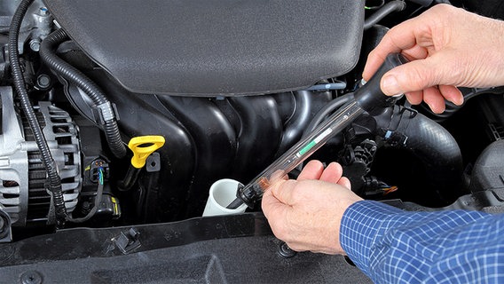 Ein Messstab wird zur Prüfung in die Kühlerflüssigkeit eines  Autos getaucht © Fotolia.com Foto: RioPatuca Images