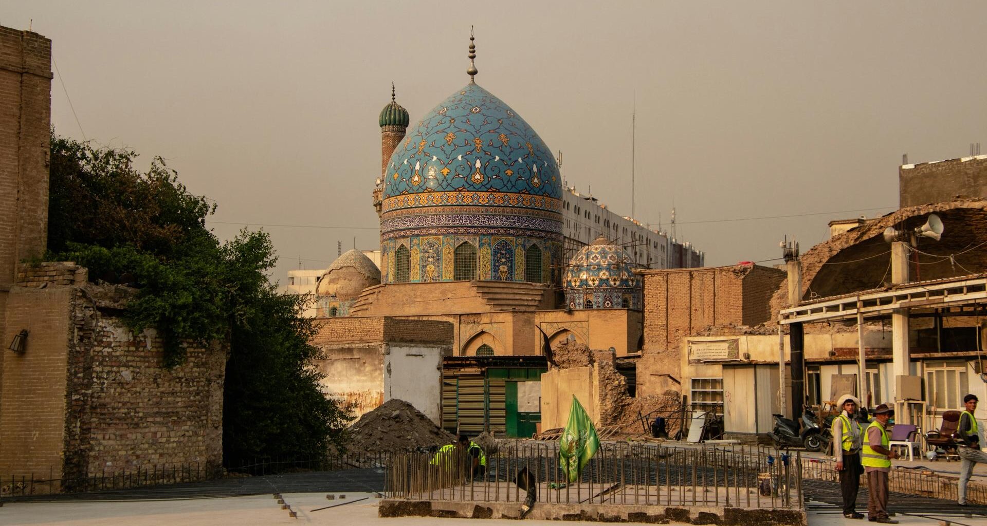 Blick auf eine Moschee mit blauer historischer Kuppel, vor der sich eine Beton-Baustelle eröffnet.
