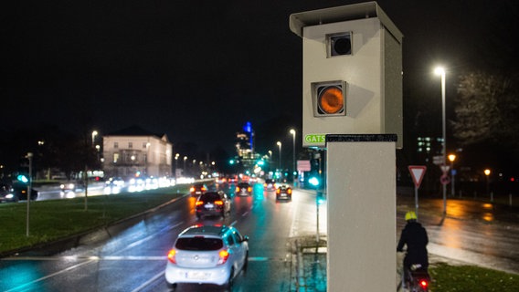 An einer Hauptstraße in Hannover steht ein Blitzer, Autos fahren im Dunkeln daran vorbei. © dpa-Bildfunk Foto: Lucas Bäuml