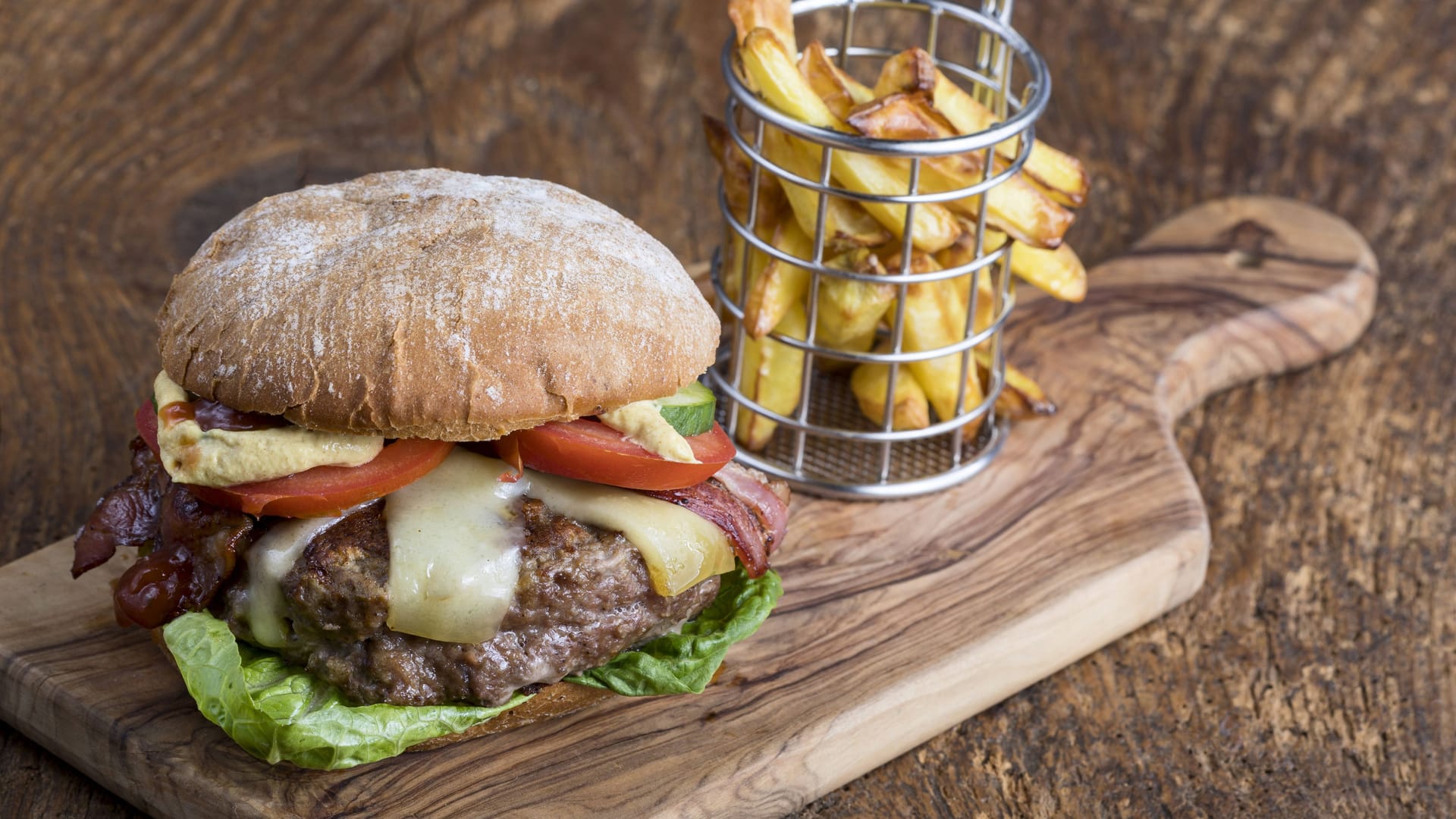 Cheeseburger mit Pommes auf Holz (Symbolbild): Im Essener Restaurant "The Ash" wurden eklatante Hygienemängel festgestellt.