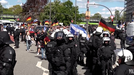 Demonstranten einer rechten Demo stehen neben Einsatzkräften der Polizei auf dem Ballindamm. © NonstopNews Foto: Screenshot