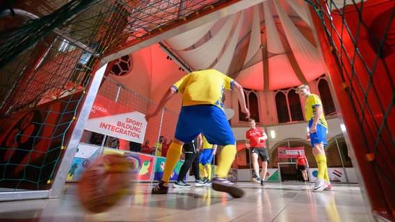 In Trikots der Bundesliga-Zweitligisten Hannover 96 und Eintracht Braunschweig spielen Pastoren und Mitarbeiter der Diakonie aus Hannover und Braunschweig in der Lutherkirche gegeneinander Fußball. © Julian Stratenschulte/dpa Foto: Julian Stratenschulte