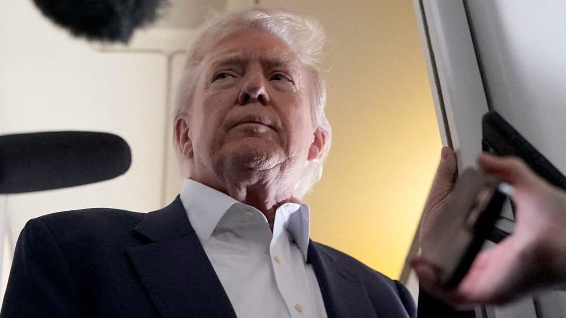 Donald Trump spricht an Bord der Präsidentenmaschine zu Journalisten.