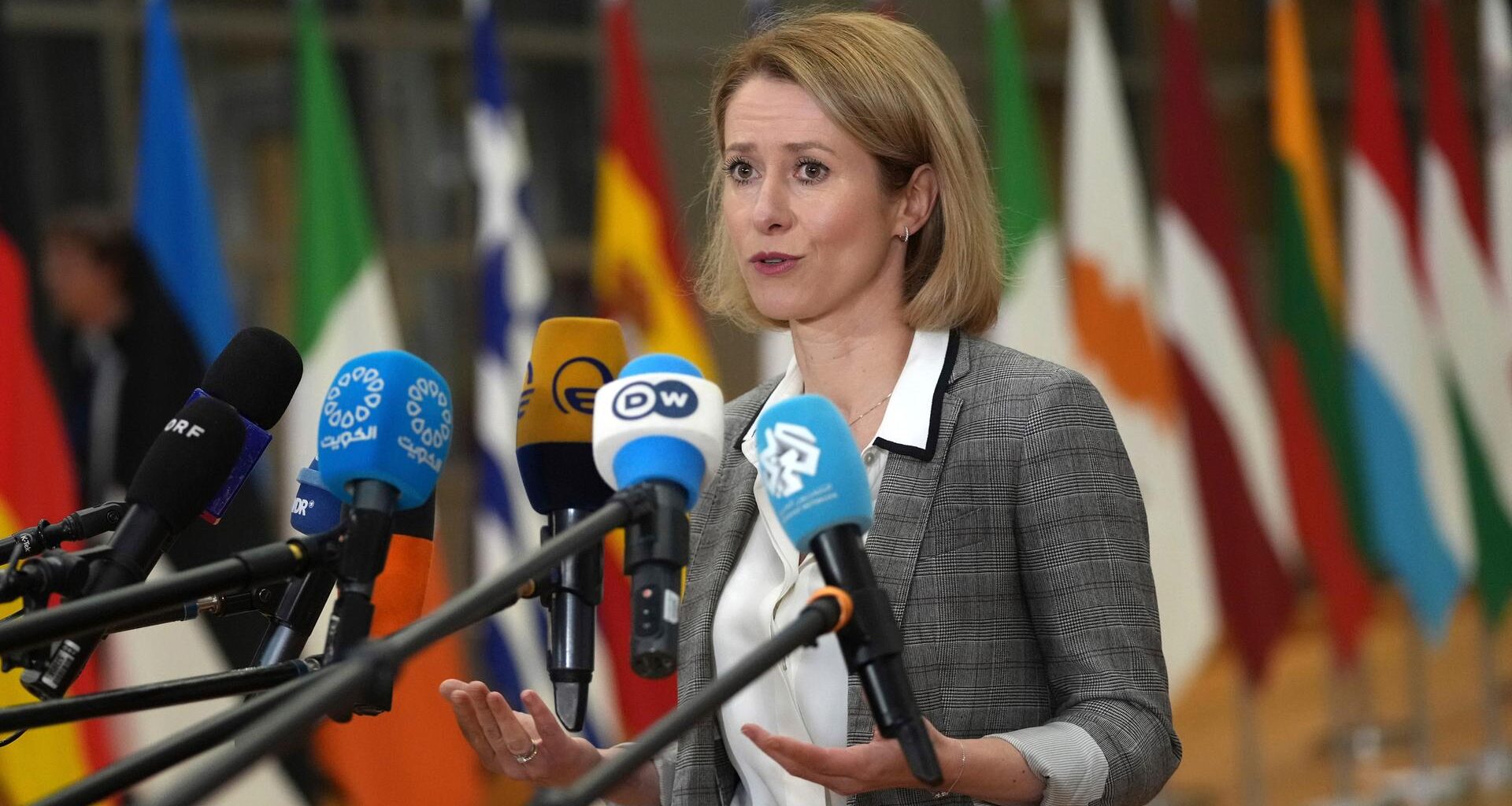 Kaja Kallas, EU-Außenbeauftragte, steht vor Mikrofonen und spricht. Hinter ihr sind etwas verschwommen zahlreiche Flaggen zu sehen.