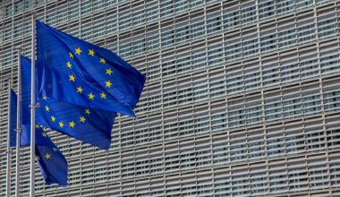 Das Berlaymont-Gebäude in Brüssel, der Sitz der Europäischen Kommission. Davor wehen drei Europafahnen.