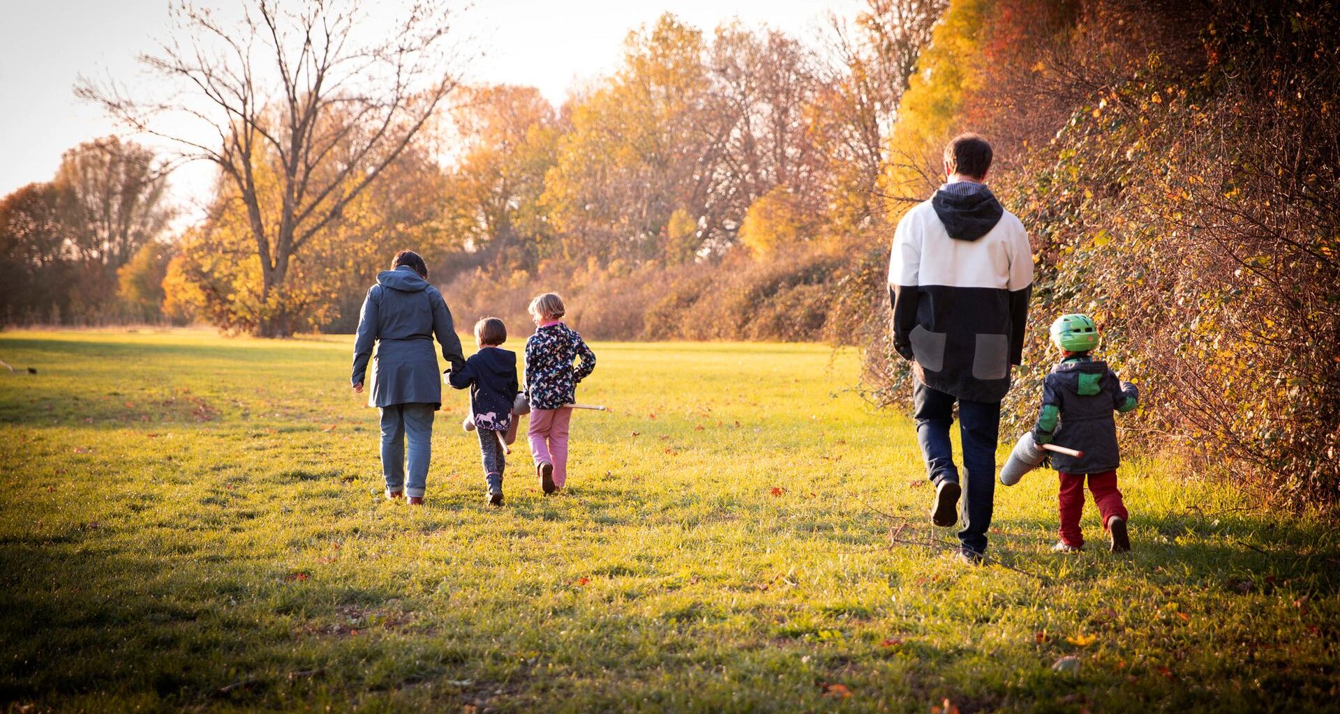 Familie beim Herbstspaziergang von hinten fotografiert