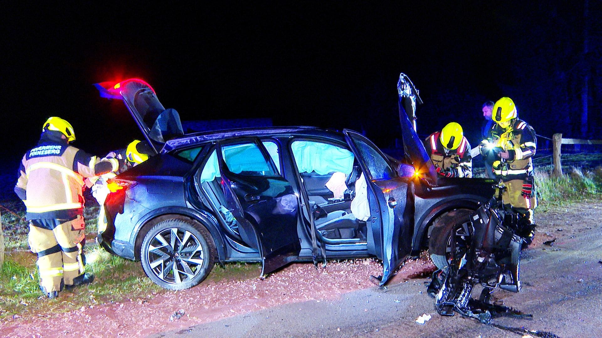 Feuerwehrleute an der Unfallstelle: Sie untersuchen das Wrack nach dem Crash gegen die Brücke.