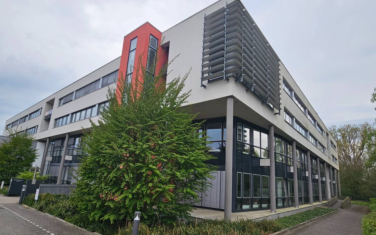 Das Gebäude des Finanzamt Münster-Innenstadt von außen. Ein modernes Gebäude mit weißer Fassade und roten Akzenten.