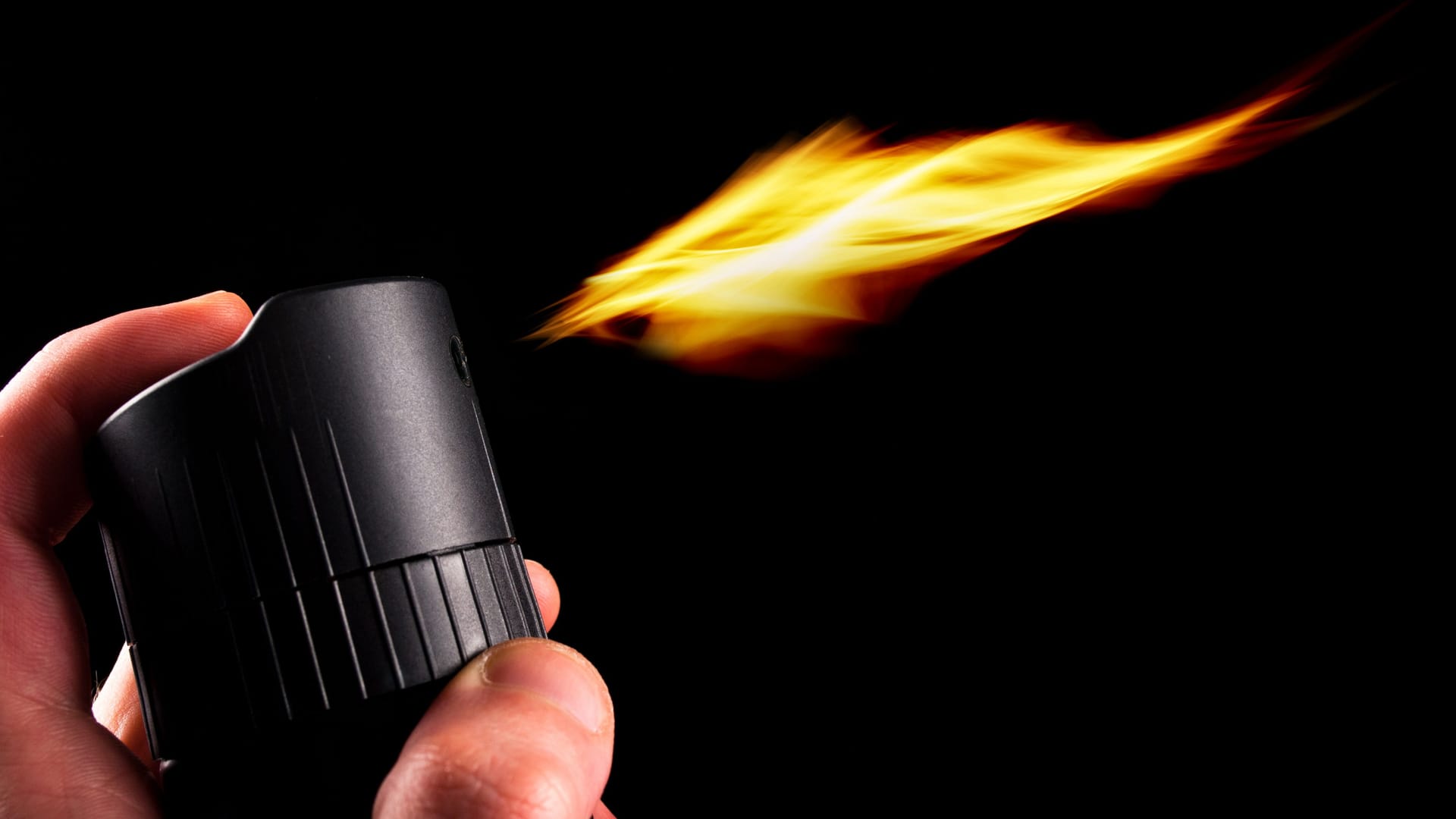 Deodorant can and fire blazing out of bottle. Close up