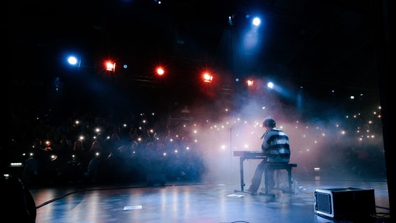 Ein Musiker spielt auf einer Bühne vor einem Publikum. © Julie Himmelstoss 