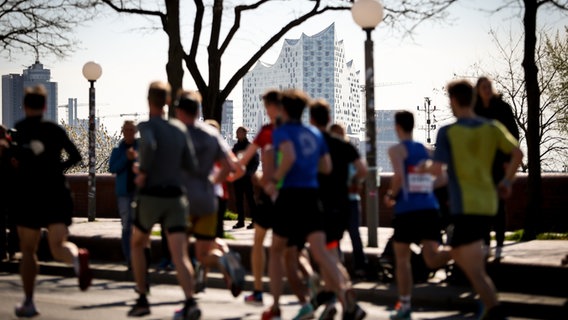 Menschen laufen bei dem Hamburg-Marathon mit. Diese Menschen laufen am Hafen. © dpa-Bildfunk Foto: Christian Charisius/dpa