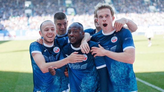 Rostock-Spieler bejubeln einen Treffer von Christian Kinsombi (M.) © IMAGO / Andy Bünning 