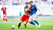 Rostocks Sigurd Haugen (l.) und Bielefelds Marius Wörl kämpfen um den Ball. © IMAGO / Noah Wedel 
