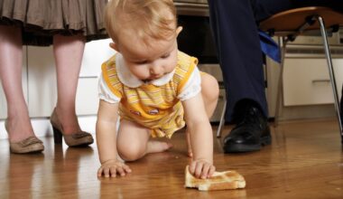 Ein kleines Mädchen krabbelt mit einem Stück Toastbrot in der Hand auf dem Boden herum.