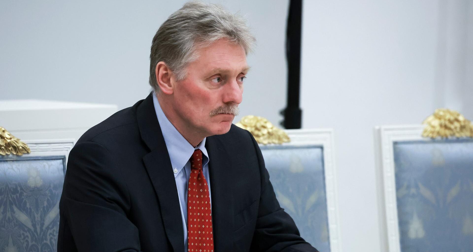 Kreml-Sprecher Dmitri Peskow sitzt im Kreml und schaut ernst.