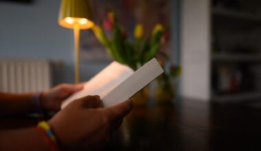 Eine Frau liest an einem Küchentisch ein Buch. (gestellte Szene)