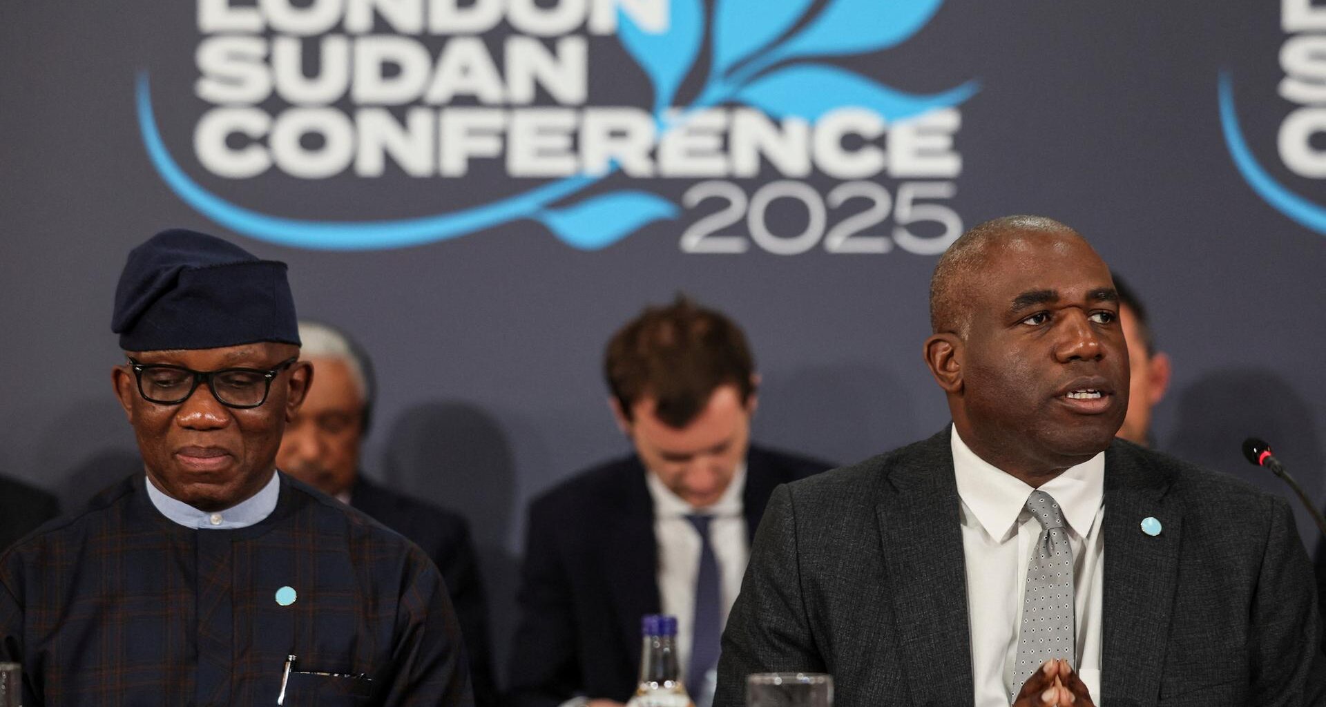 Bankole Adeoye, nigerianischer Diplomat und Großbritanniens Außenminister Lammy sitzen während der Konferenz nebeneinander. Hinter ihnen das Logo der Konferenz "London Sudan Conference 2025".
