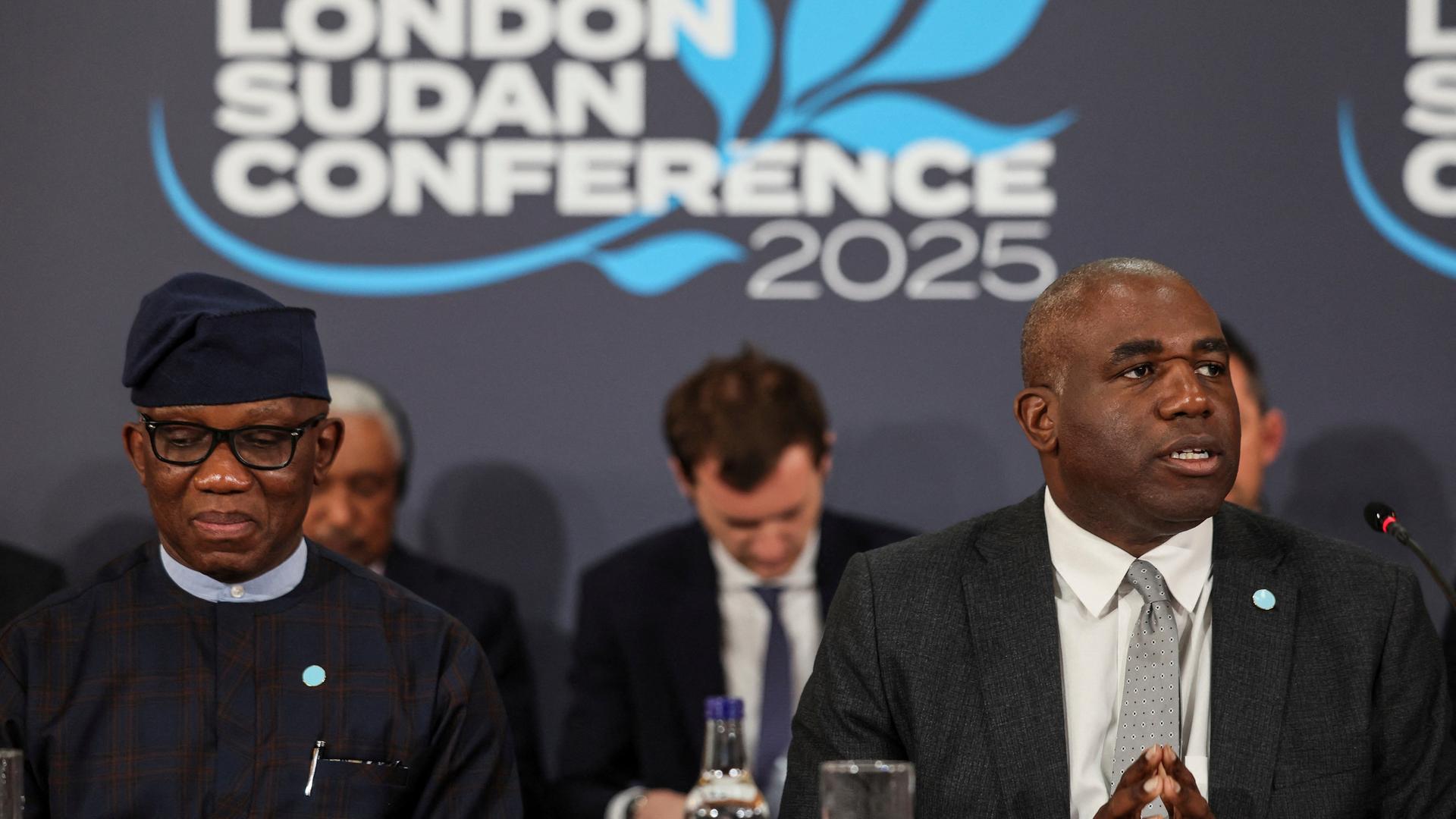 Bankole Adeoye, nigerianischer Diplomat und Großbritanniens Außenminister Lammy sitzen während der Konferenz nebeneinander. Hinter ihnen das Logo der Konferenz "London Sudan Conference 2025".