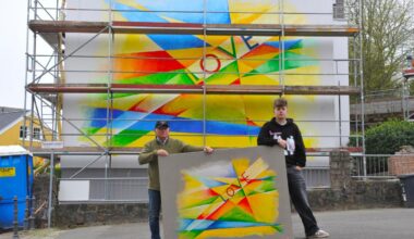 Opa und Enkel malen „Love“ auf Hauswand