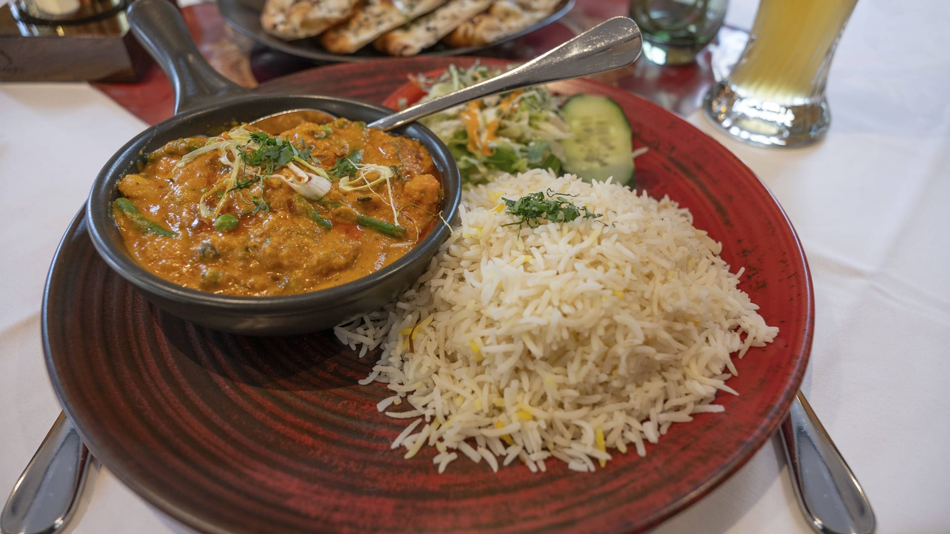Mango Chicken, Hühnerfleisch in frischer Mango-Safran Cashewnuss Mandelsauce und mit Reis serviert in einem Indischen Restaurant (Symbolbild).