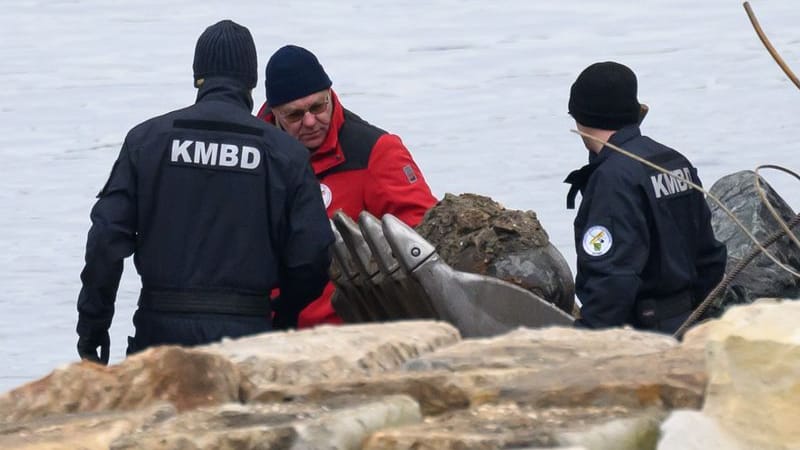 Mitarbeiter der Kampfmittelbeseitigung (KMBD) betrachten eine Bombe in der Schaufel eines Baggers, die auf dem Abrissfeld der teileingestürzten Carolabrücke entdeckt wurde (Archivbild):
