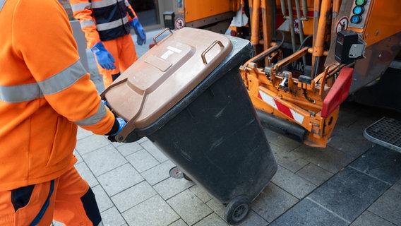 Ein Mitarbeiter der Müllabfuhr leert in der Innenstadt eine Biomülltonne. © picture alliance Foto: Marijan Murat