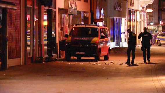 Polizisten und ein Polizeiauto an einem Tatort in Oldenburg, an dem ein Mensch erschossen wurde. © NonstopNews 