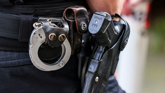 Ein Polizeibeamter trägt seine Dienstwaffe Walther P99 und Handschellen (Themenbild) © picture alliance/dpa Foto: Christoph Reichwein