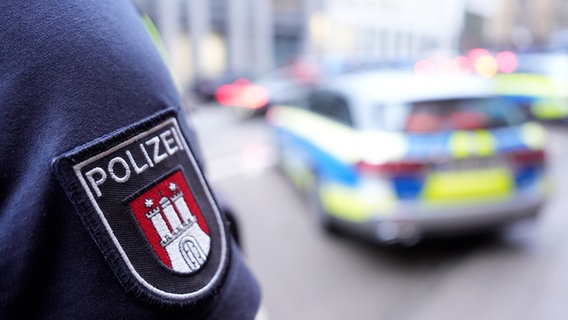 Ein Polizist steht vor einem Einsatzfahrzeug der Polizei. © picture alliance/dpa Foto: Marcus Brandt