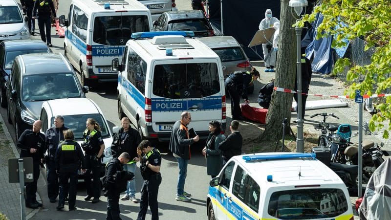 Polizisten und Beamte der Spurensicherung in weißen Schutzanzügen stehen am Fundort. Wegen einer männlichen Leiche wurde die Polizei am Morgen alarmiert. Die Umstände deuten auf eine Gewalttat hin. Der Obdachlosen starb laut Staatsanwaltschaft nach Gewalteinwirkung an Herzversagen. (zu dpa: «Mann in Berlin auf Gehweg getötet - Handwerker im Fokus»)