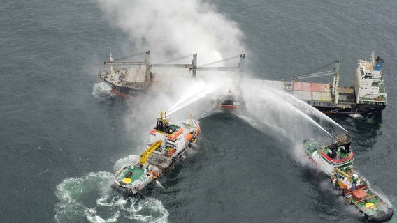 Der Notfall-Hochseeschlepper "Nordic" und das Mehrzweckschiff «Neuwerk» löschen am 27.05.2015 den Brand auf dem brennenden Frachter "Purple Beach" in der deutschen Bucht in der Nordsee bei Helgoland. © picture alliance / dpa | Havariekommando 