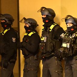 Archivbild: Bewaffnete und vermummte Polizeibeamte stehen in der Nacht an einem Haus. (Quelle: dpa/Zinken)