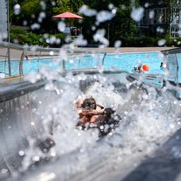 Kinder rutschen im Sommerbad Neukölln ins Schwimmbecken. (Quelle: dpa/Bernd von Jutrczenka)