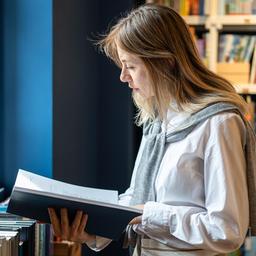 Symbolbild: Ein Frau liest ein Buch im Buchladen. (Quelle: dpa/Dmitrii Marchenko)