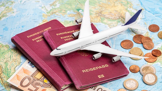 Stilleben mit Flugzeugmodell, Globus, Reisepässen und Geld © fotolia.com Foto: eyetronic