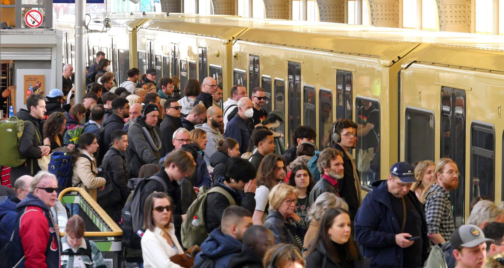 Menschen stehen am Bahnhof vor der S-Bahn